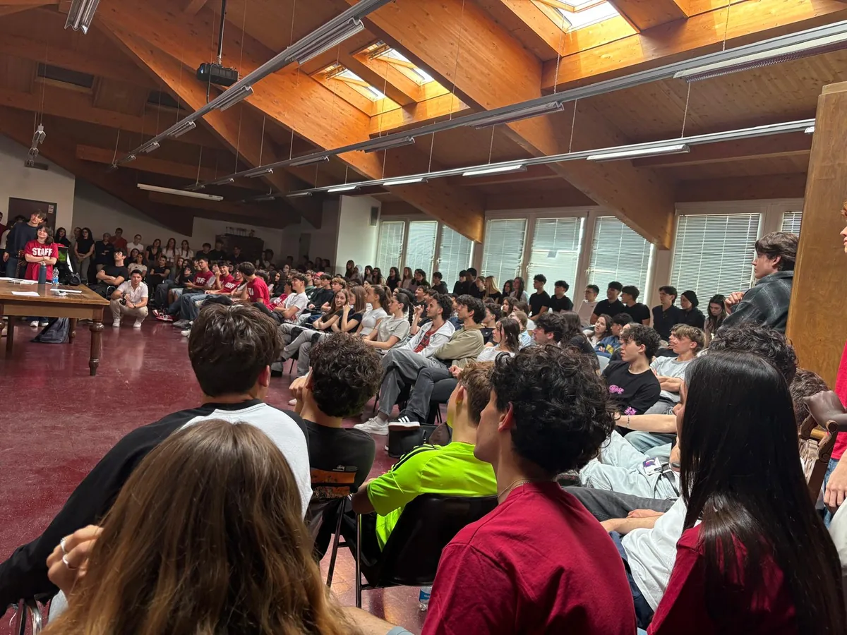 Una sala sotto il tetto con le travi di legno, piena di studenti seduti in cerchio durante un incontro pomeridiano organizzato dallo staff degli studenti